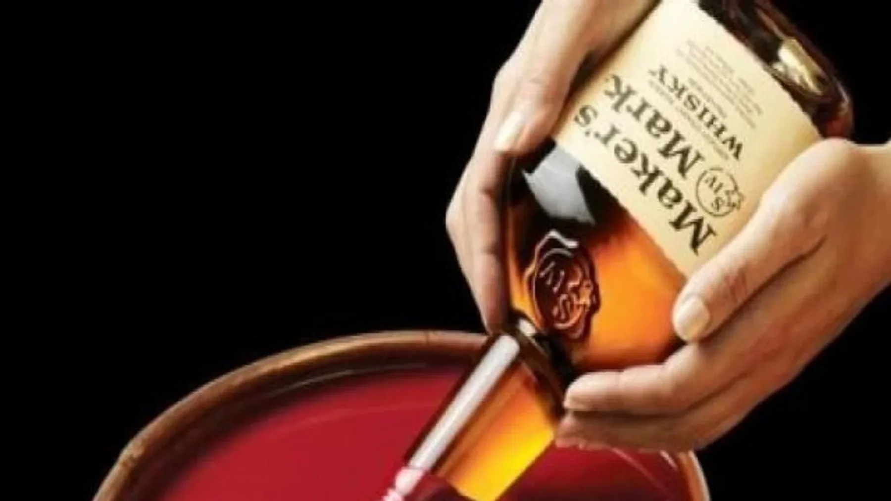 Sıcak kırmızı muma batırılmış, konyak şişesini andıran cam Maker's Mark Bourbon şişesi.